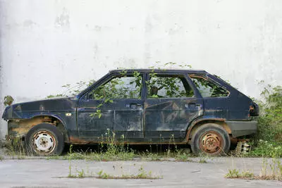 Abandoned Vehicle with Overgrown Weeds
